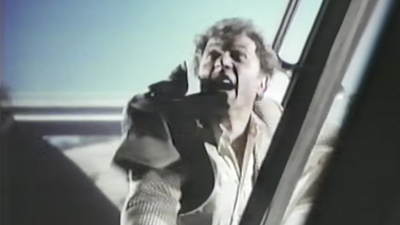 Steve Lawrence as Mike Post looking terrified while holding onto the outside of the Supertrain in Supertrain (1979)