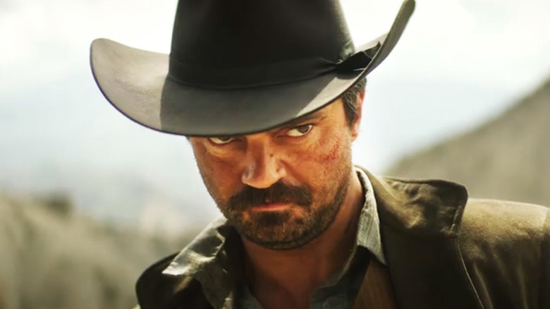 Dominic Cooper's Arthur McCoy looks up from under his hat in closeup in That Dirty Black Bag