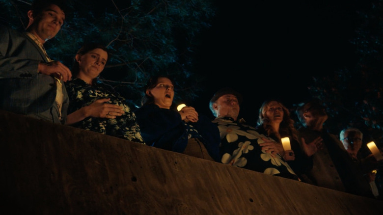 Tillie's family and Rabbi holding candles in D(e)ad