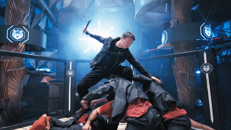 Xie Miao's Wang Wei stands atop a pile of thugs wielding a hammer in The Furious