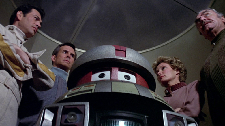 The crew of the USS Palomino gathered around V.I.N.CENT. in The Black Hole