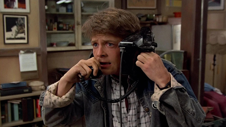 Michael J. Fox as Marty McFly holding a phone up to his head in Back to the Future