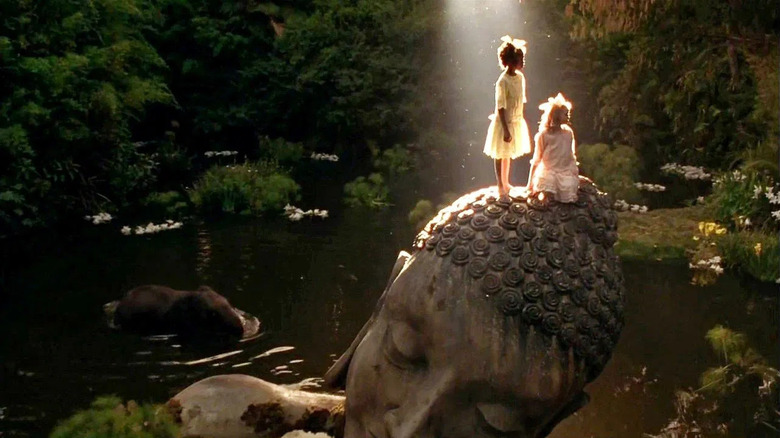 Sarah and Becky standong on a giant statue of Siddartha in A Little Princess