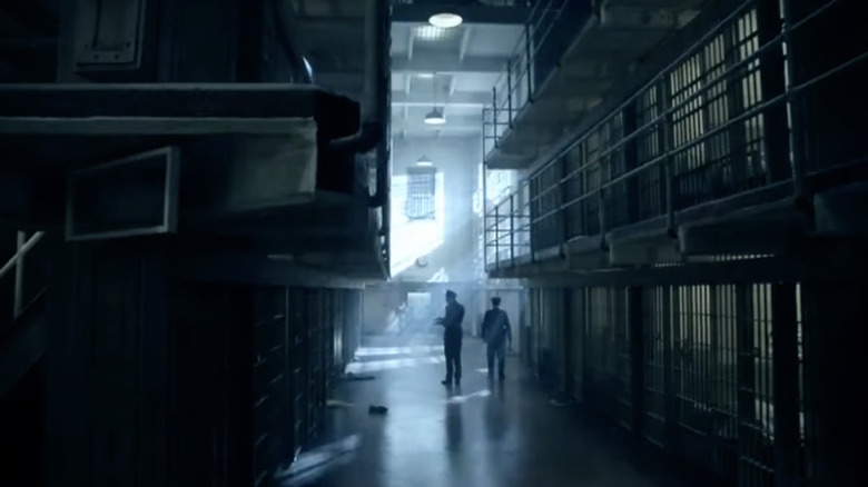 Two prison guards staring at empty prisoner cells in Alcatraz