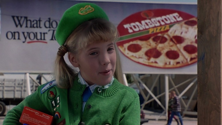 The Adams Family - Girl Scout (Mercedes McNab) met pizzareclamebord achter haar