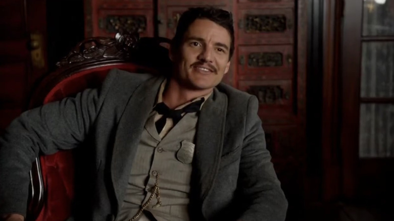 Pedro Pascal's Agent Ortega smiles as he sits in an office in The Sixth Gun