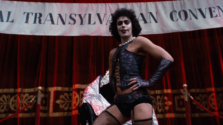 Dr. Frank-N-Furter posing in front of a banner in The Rocky Horror Picture Show