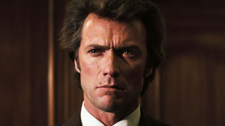 Clint Eastwood's Harry Callahan is seen in closeup as he stands in a dark wood paneled room in Dirty Harry