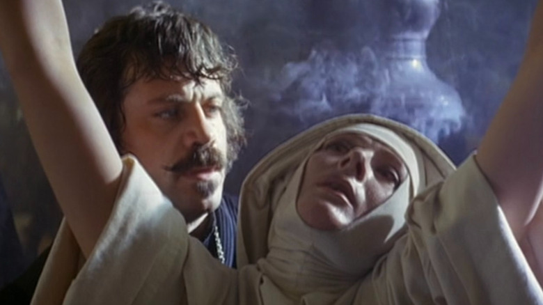 Pastor Grandier memandang Suster Jeanne dengan tangan terangkat ke dalam The Devils