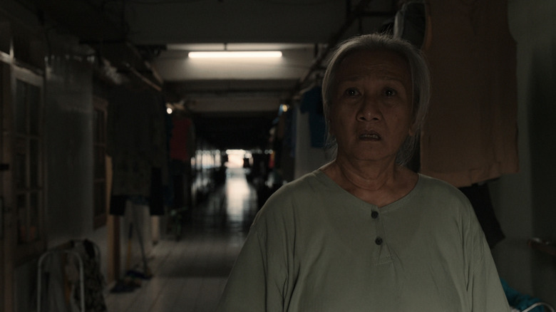 Yatti Surachman's Ranti stands looking worried in a hallway in Joko Anwar's Nightmares and Daydreams