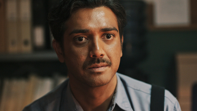 Fachry Albar's Ali sits in an office looking across frame in Joko Anwar's Nightmares and Daydreams