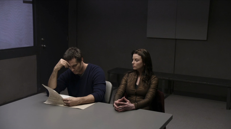 Rachel Nichols' Kiera Cameron sits in an interrogation room next to Victor Webster's Carlos Fonnegra in Continuum