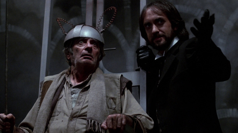 Jonathan Pryce as Mr. Dark gestures in front of a victim in an electric chair in Something Wicked This Way Comes