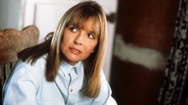 Anna Dunlop sits in a chair and leans forward in The Good Mother