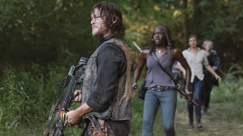 Norman Reedus as Daryl Dixon holding his crossbow with Dani Gurira as Michonne behind him in the Walking Dead episode What Comes After