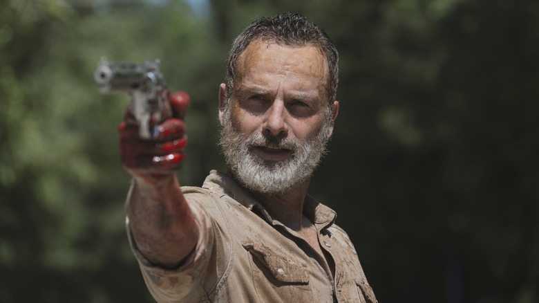 Andrew Lincoln as Rick Grimes holding up his gun in the Walking Dead episode What Comes After