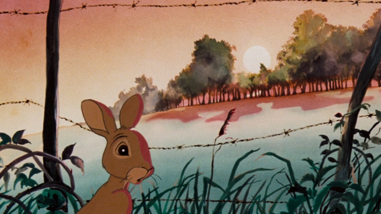 Fiver the rabbit in front of a fence while a field fills with blood in Watership Down