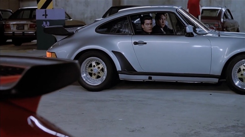 D.B. Sweeney as Benjy Taylor and Charlie Sheen as Ted Varrick prowl a parking garage in a Porsche in No Man's Land