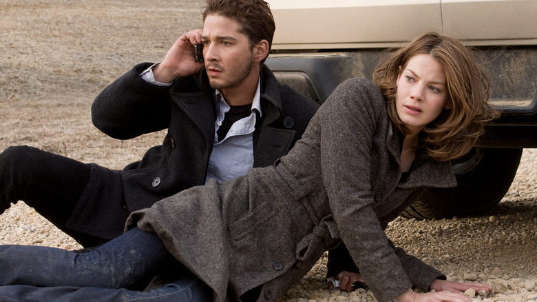Jerry and Rachel lie on the ground shielding themselves from danger in Eagle Eye