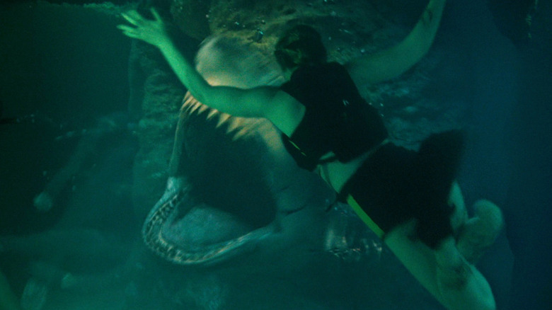 A shark opens its jaws as a diver struggles in the foreground in The Devil's Mouth