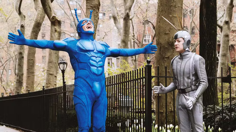 The Tick in a T-pose with Arthur beside him in The Tick