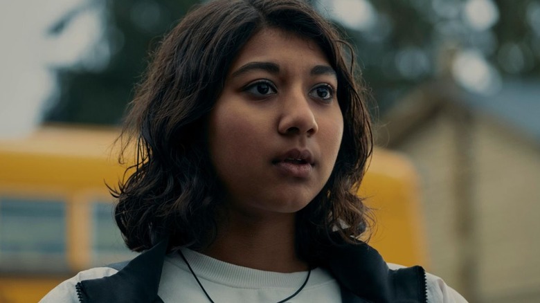 Reena standing next to a school bus in Under the Bridge