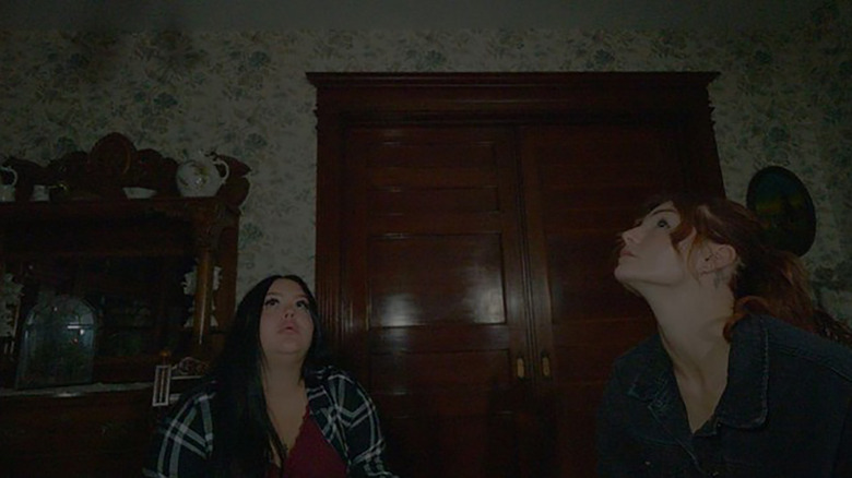 Celina and Kris listening to a ghost in House on Eden