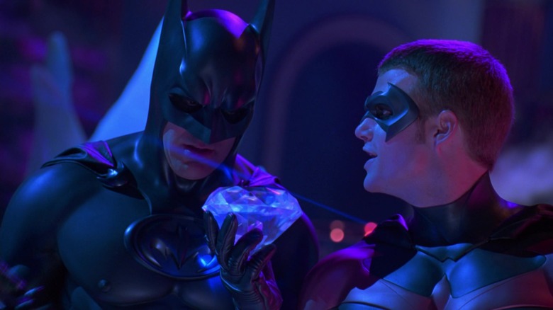 Batman looking at a huge diamond that Robin in holding in Batman & Robin