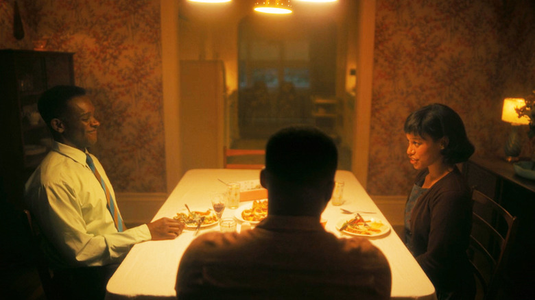 Chris Chalk's Dick Hallorann sits at a dinner table with Taylour Paige's Charlotte Hanlon and Jovan Adepo's Leroy Hanlon in It Welcome to Derry