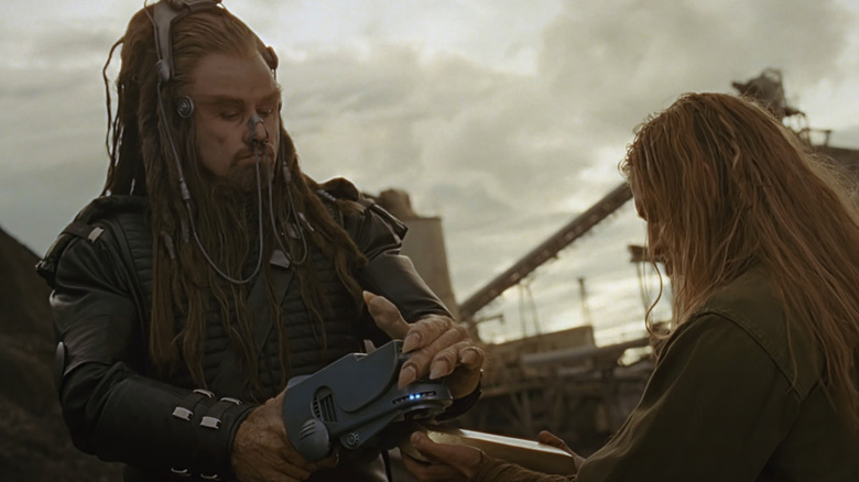 Terl John Travolta looks down while carrying a device in the battlefield