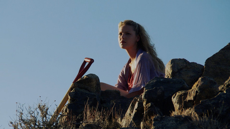 Marissa sitting next to a shovel in the desert in Zyzzyz Road
