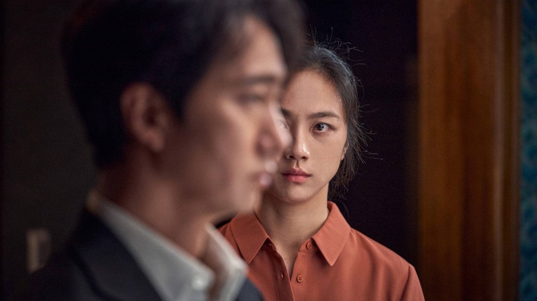Tang Wei as Seo-Rae staring at Park Hae-il as Hae-Jun (who is looking away) in Decision to Leave