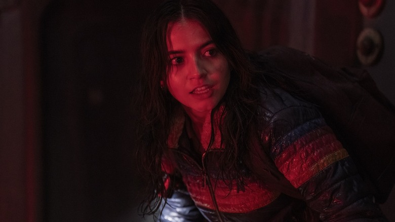 Dina bathed in red light looking scared in The Last of Us
