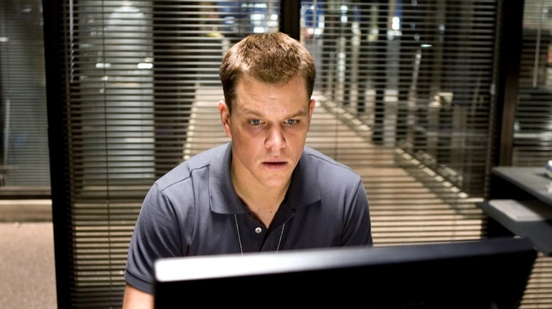Colin at a computer looking shocked in The Departed