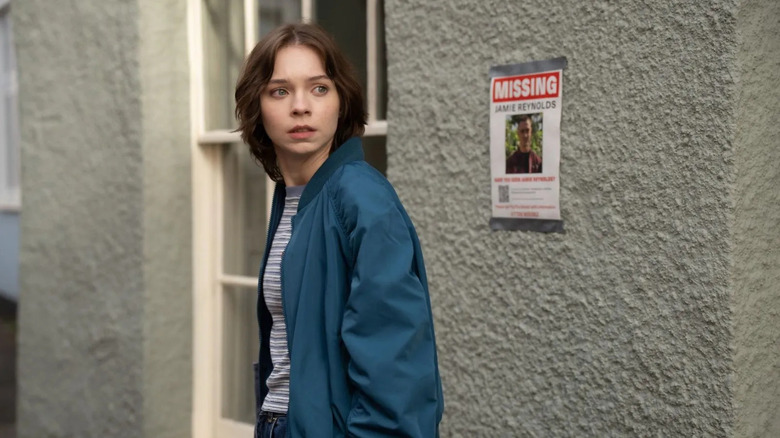 Pip in front of a missing persons poster on A Good Girl's Guide to Murder