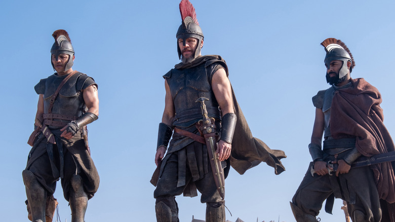 Odysseus and his men standing on a beach, weapons ready, in The Odyssey