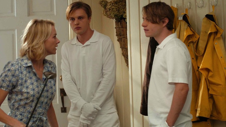 Ann with a golf club, talking to Paul and Peter in a hallway in Funny Games