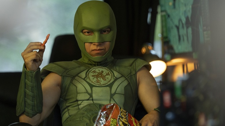 Nhut Le as Judomaster, enjoying some Flaming Hot Cheetos, on Peacemaker season 1