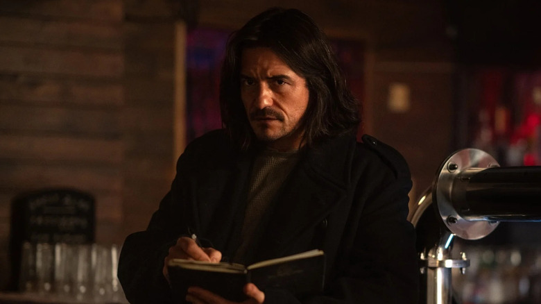 Orlando Bloom reads a book at the bar as Marlon Swift in Deep Cover
