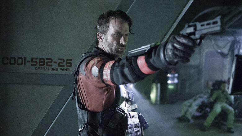 ది ఎక్స్‌పాన్స్‌లో తుపాకీ పట్టుకున్న జో పాత్రలో థామస్ జేన్