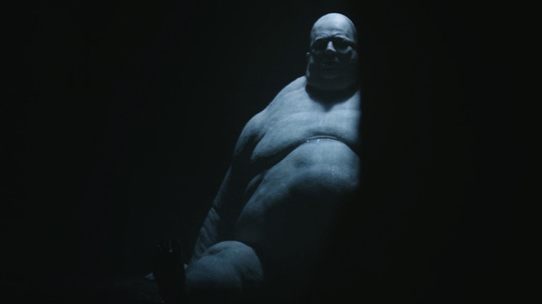 The illuminated Fat Man sitting in the darkness