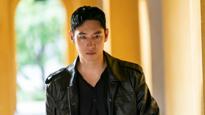 Kim Do-gi (Lee Je-hoon) stands sullenly in a black leather jacket in Taxi Driver