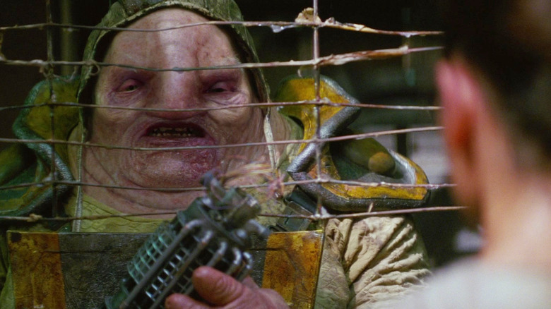 Simon Pegg como Unkar Plutt fazendo um acordo com Rey em Star Wars: O Despertar da Força