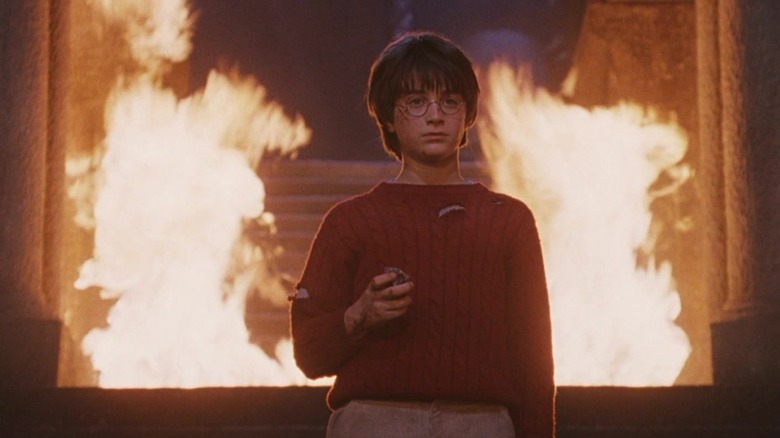 Harry Potter surrounded by flames holding the Sorcerer's Stone in Harry Potter and the Sorcerer's Stone