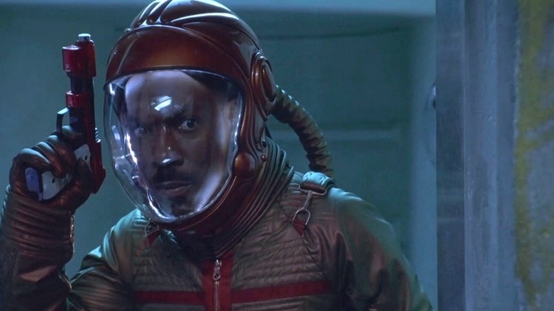 Eddie Murphy brandishes a gun in a spacesuit as Pluto Nash in The Adventures of Pluto Nash
