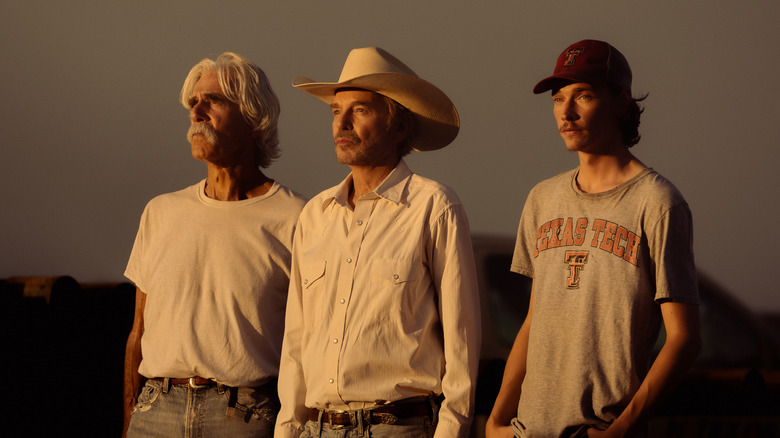 Sam Elliott's T.L. Norris stands alongside Billy Bob Thornton's Tommy Norris and Jacob Lofland's Cooper Norris against a clear sky in Landman