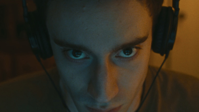 Théodore Pellerin's Matthew Morning looks sinister in closeup as he wears headphones in Lurker