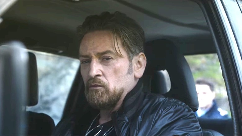 Benoît Magimel keeps an eye on his car's side mirror as a man approaches in The Hunt