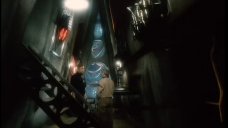 ఆండ్రూ హర్లాన్‌గా ఒలేగ్ వావిలోవ్ ది ఎండ్ ఆఫ్ ఎటర్నిటీలో చీకటి డిస్టోపియన్ గదిలో మరొక వ్యక్తితో మాట్లాడుతున్నాడు