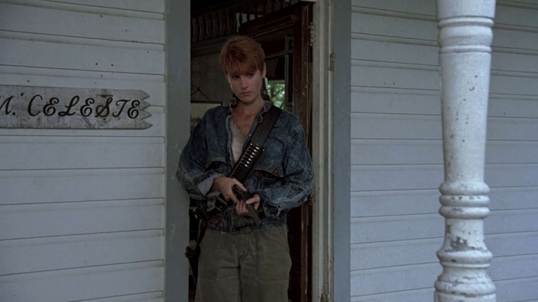 Barbara stands on a balcony and holds a gun on the night of the 1990 living dead